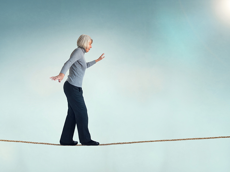 senior woman walking on a tightrope