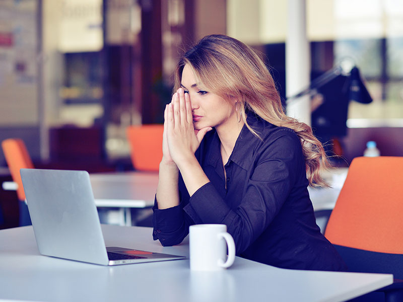 Young business woman suffering stress working at office computer