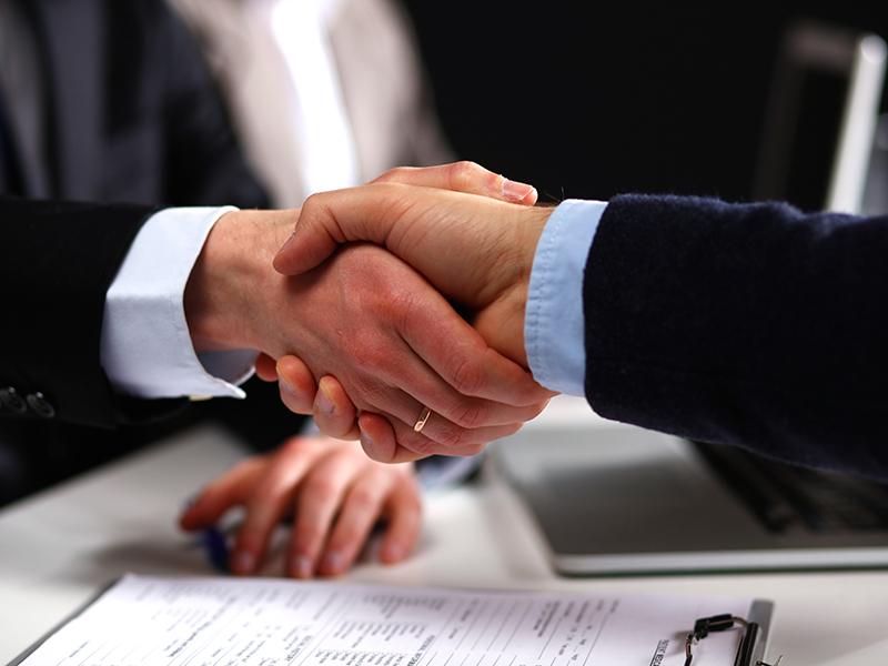 Men in suits shaking hands over contracts