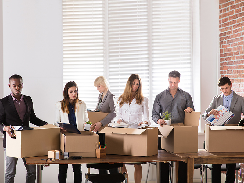 Group Of Diverse Businesspeople Packing Their Belongings In Cardboard Box At Office