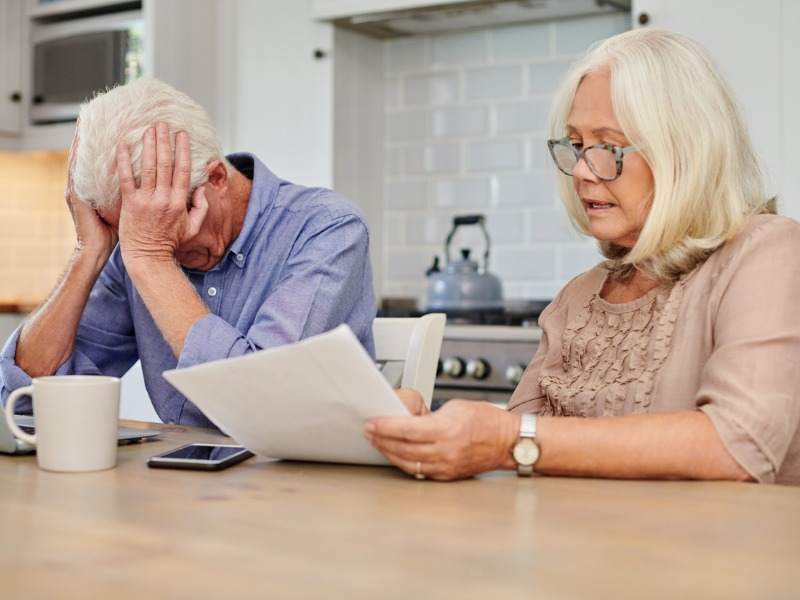 Shot of a senior couple looking unhappy while going through paperwork at home stock photo