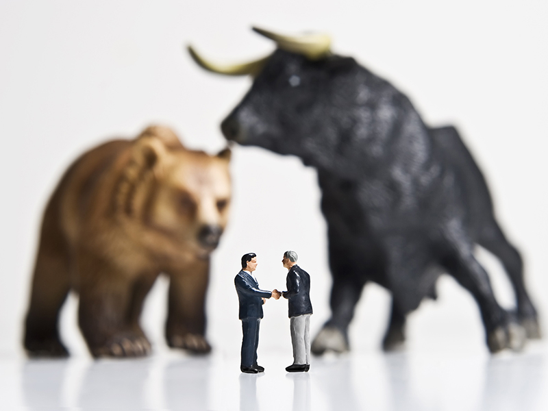 Business figurines placed with bull and bear figurines.
