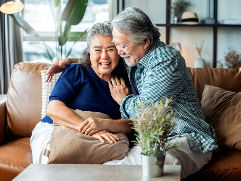 Retired couple having conversation on sofa|HomeEquity Bank logo|HomeEquity Bank logo