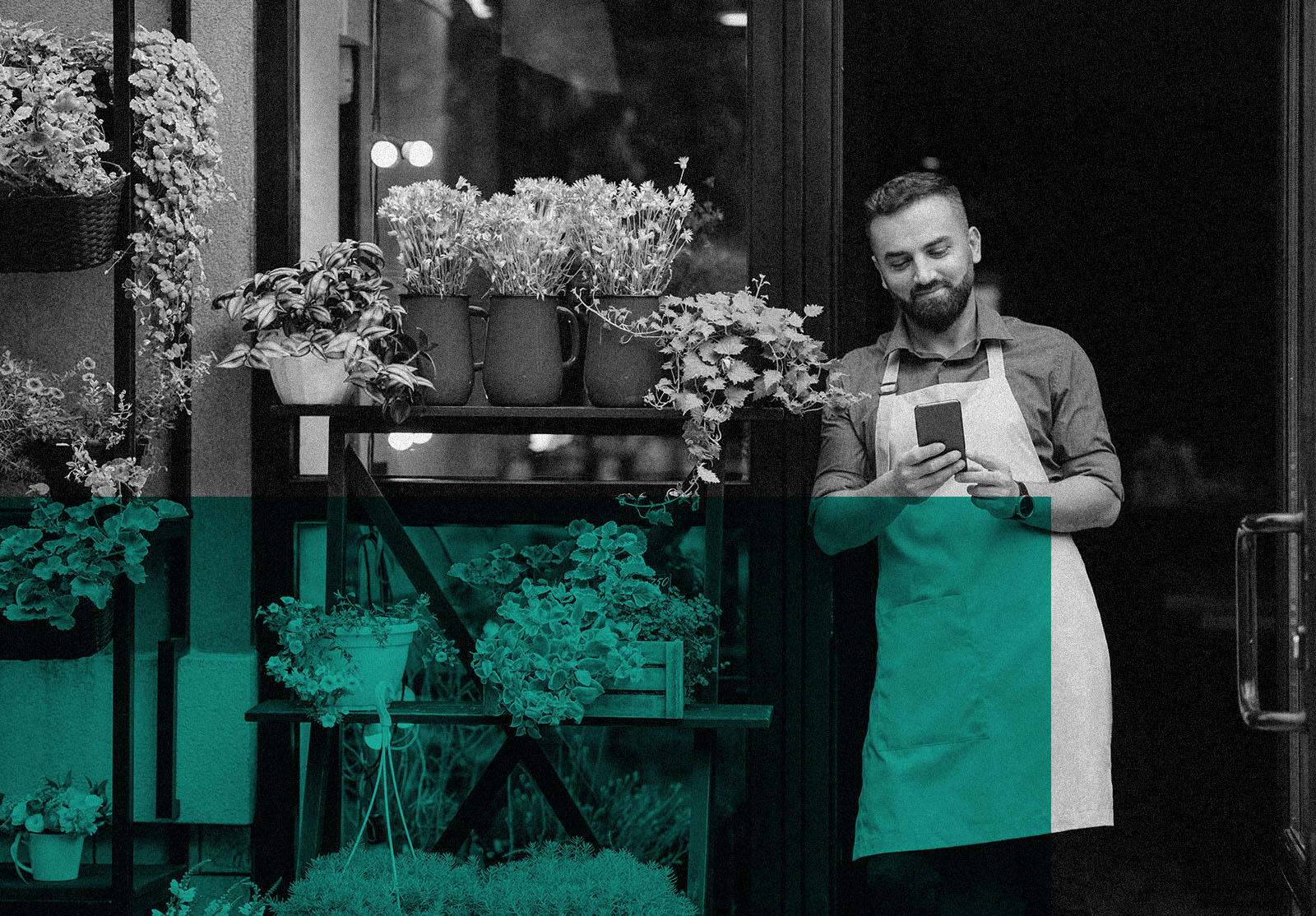 Smiling man in apron in frontof his flower shop